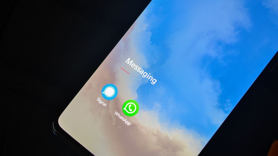 Close-up of smartphone screen showing Signal and WhatsApp messaging apps.